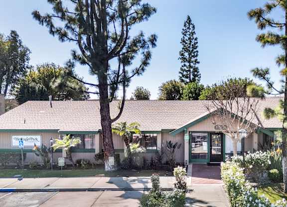 A building with a green awning and a sign that says at Heritage Park, Rialto, CA 92376