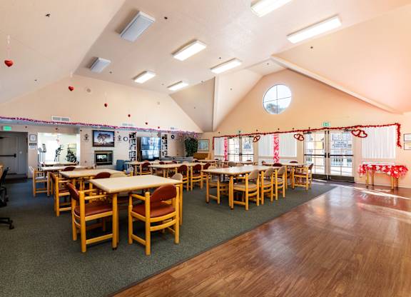 A room with tables and chairs is decorated with red ribbons. at Whispering Fountains Diamond Bar, Diamond Bar, CA 91765