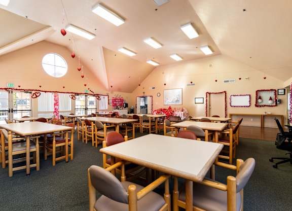 A classroom with tables and chairs and a window. at Whispering Fountains Diamond Bar, California