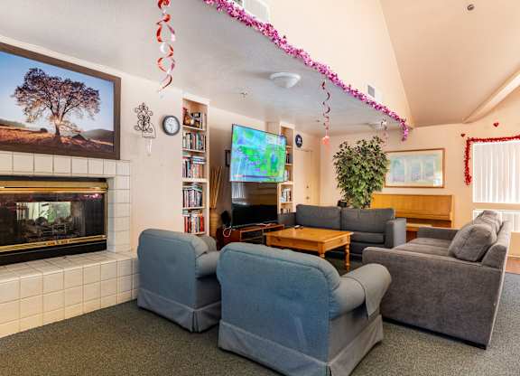 A living room with a fireplace and a painting of a tree above it. at Whispering Fountains Diamond Bar, California