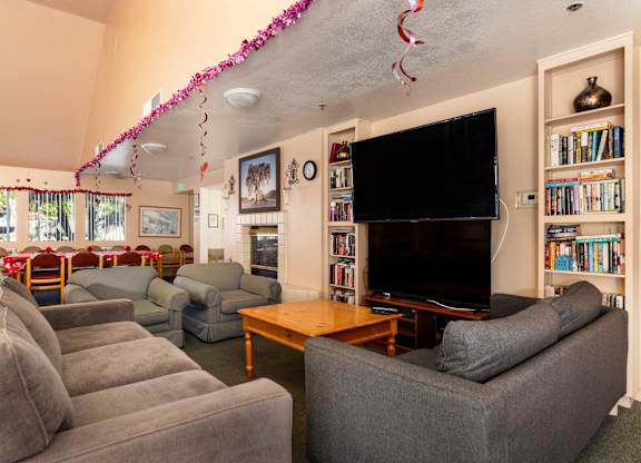 A living room with grey couches and a television. at Whispering Fountains Diamond Bar, Diamond Bar