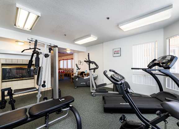 A gym with a variety of equipment including a treadmill, a stationary bike, and a rowing machine. at Whispering Fountains Diamond Bar, Diamond Bar