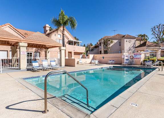 A swimming pool in a residential area with a house in the background. at Whispering Fountains Diamond Bar, Diamond Bar, 91765