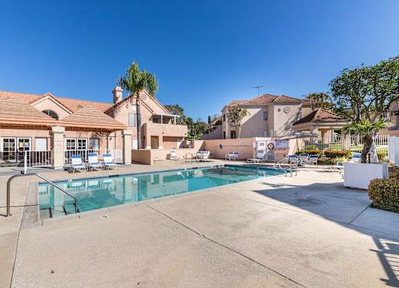 A swimming pool in a residential area with houses in the background. at Whispering Fountains Diamond Bar, Diamond Bar California