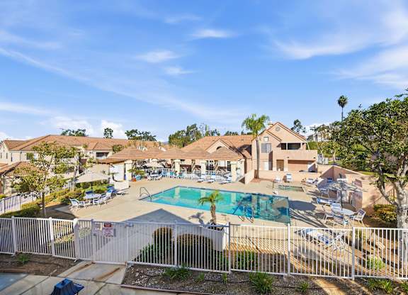 A residential area with a pool and a fence. at Whispering Fountains Diamond Bar, Diamond Bar, CA 91765