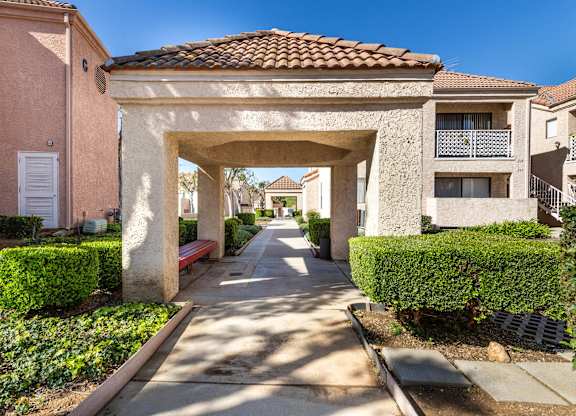 A sunny day in a residential area with a street leading to a covered walkway. at Whispering Fountains Diamond Bar, Diamond Bar, CA 91765