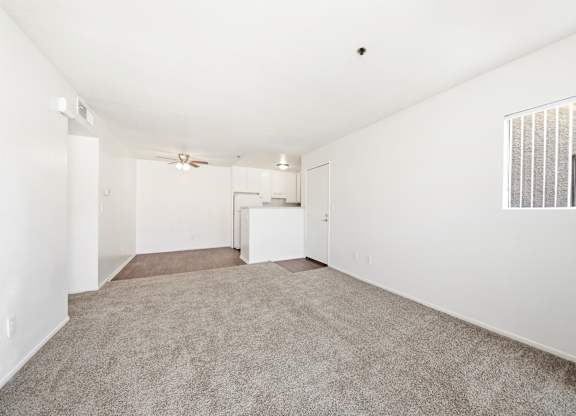 A spacious, empty room with a carpeted floor and a window with blinds. at Whispering Fountains Diamond Bar, Diamond Bar, CA 91765