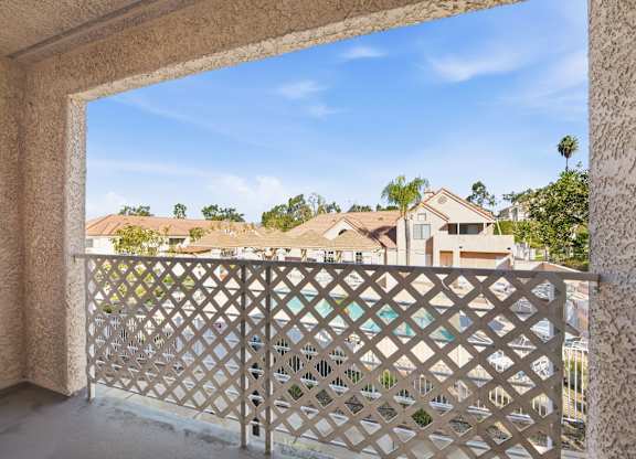 A balcony with a lattice railing overlooks a residential area. at Whispering Fountains Diamond Bar, California, 91765