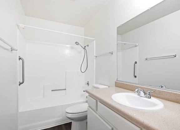 A white bathroom with a toilet, sink, and shower. at Whispering Fountains Diamond Bar, California, 91765
