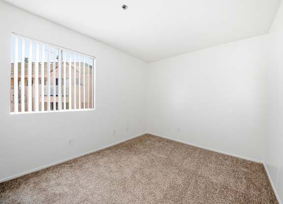 A room with a carpeted floor and a window with blinds. at Whispering Fountains Diamond Bar, Diamond Bar