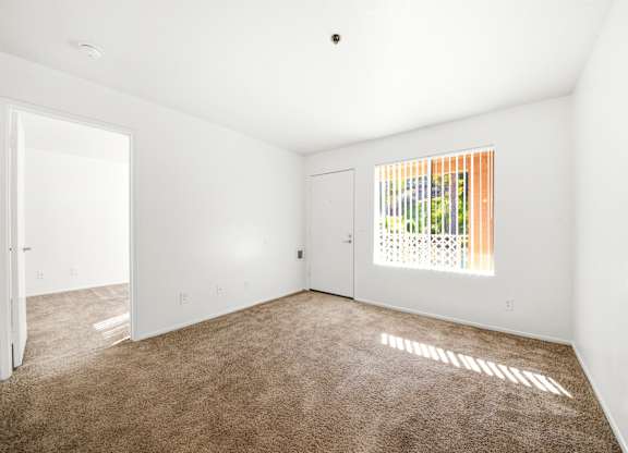 A room with a brown carpet and a window with blinds. at Whispering Fountains Diamond Bar, Diamond Bar California