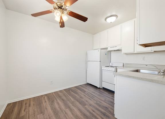 A kitchen witA kitchen with white cabinets and a wooden floor white cabinets and a wooden floor. at Whispering Fountains Diamond Bar, Diamond Bar, CA
