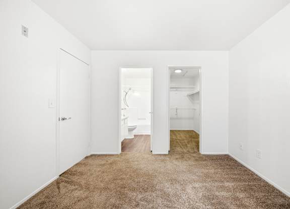 A white room with a carpeted floor and a door on the left. at Whispering Fountains Diamond Bar, Diamond Bar, 91765