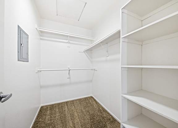 A white closet with shelves and a carpeted floor. at Whispering Fountains Diamond Bar, Diamond Bar, CA