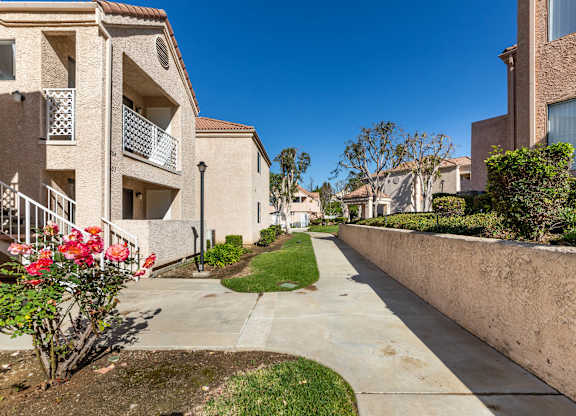 A row of houses with a concrete walkway between them. at Whispering Fountains Diamond Bar, California, 91765
