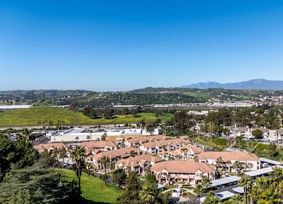 A residential area with houses and greenery under a clear blue sky. at Whispering Fountains Diamond Bar, Diamond Bar California