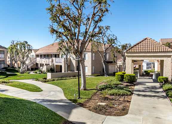 A residential area with houses and a tree in the foreground. at Whispering Fountains Diamond Bar, Diamond Bar, CA