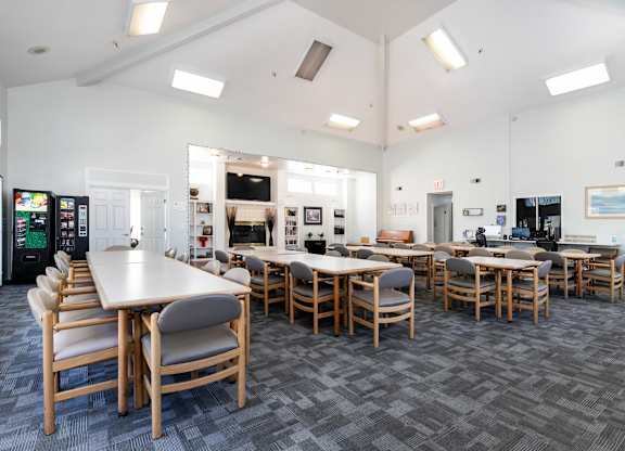 A room with tables and chairs and a vending machine. at Whispering Fountains Lakewood, Lakewood Bar, CA 90805
