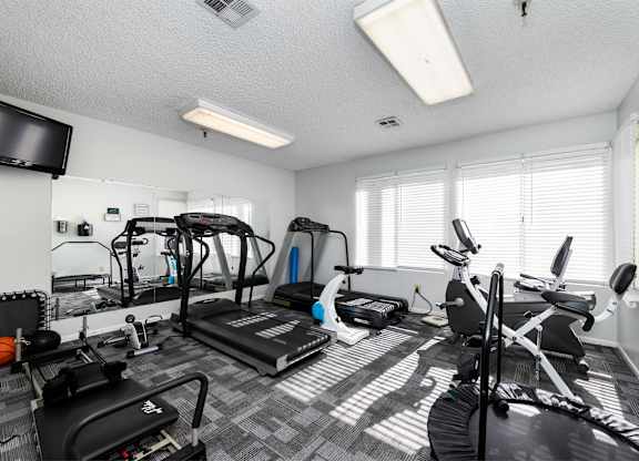 A well-equipped home gym with a variety of exercise machines. at Whispering Fountains Lakewood, California, 90805