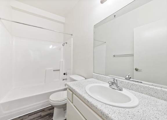 White bathroom with sink and bathtub at Whispering Fountains Lakewood, Lakewood Bar, 90805