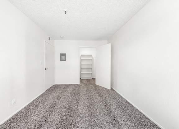A long, empty hallway with a carpeted floor and white walls. at Whispering Fountains Lakewood, Lakewood Bar, CA 90805