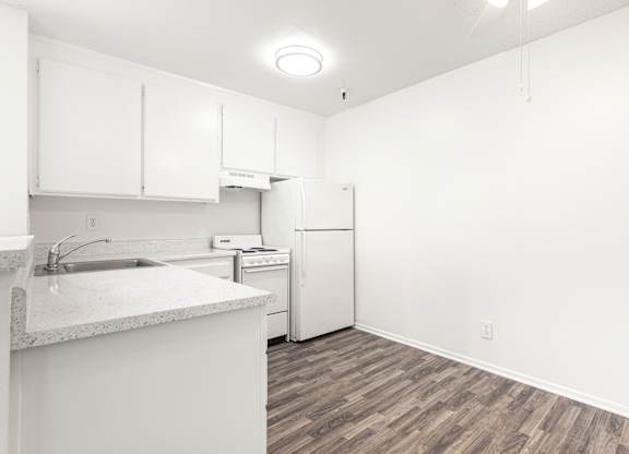 A kitchen with white cabinets and a white fridge. at Whispering Fountains Lakewood, Lakewood Bar