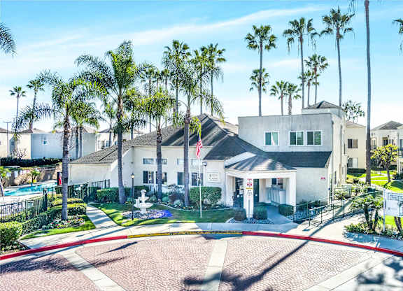 A white house with a pool in front of it. at Whispering Fountains Lakewood, Lakewood Bar