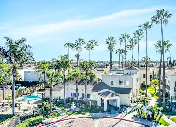 A row of palm trees around apartment at Whispering Fountains Lakewood, Lakewood Bar California