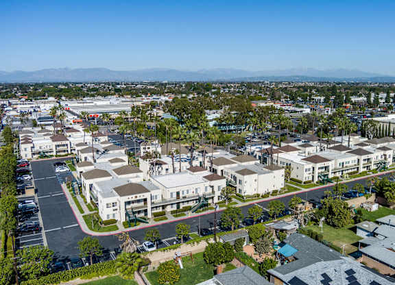 A view of a residential area with houses and a parking lot. at Whispering Fountains Lakewood, Lakewood Bar, 90805