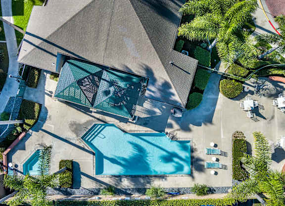 An aerial view of a house with a pool and a patio area. at Whispering Fountains Lakewood, Lakewood Bar, CA