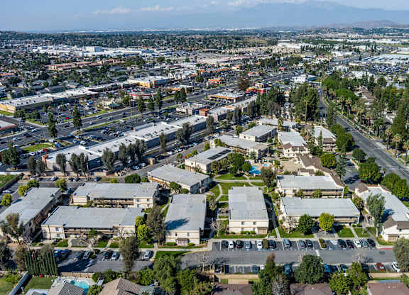 Bird's eye view of a residential area with houses, roads, and trees at Whispering Fountains Riverside, Riverside, CA