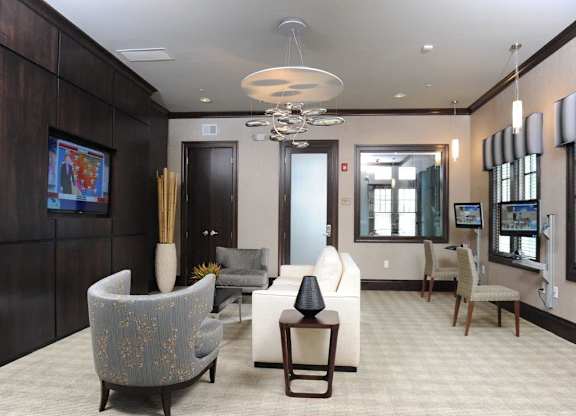 A living room with a grey sofa and a white armchair at Vermella Lyndhurst apartments, Lyndhurst, NJ