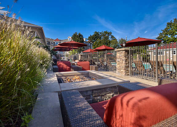 A patio with red umbrellas and a grill at Vermella Lyndhurst apartments, New Jersey, 07071