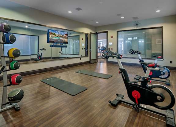 A gym with a row of exercise bikes and a television mounted on the wall at Vermella Lyndhurst apartments, Lyndhurst 07071