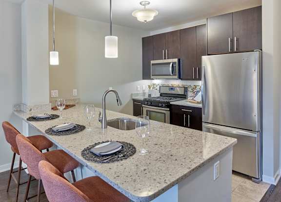 Functional kitchen island and stainless steel appliances at Vermella Lyndhurst apartments, New Jersey, 07071