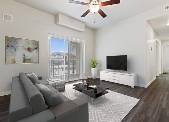 a living room with a ceiling fan and a large window