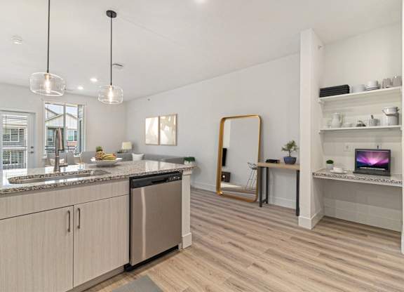 A modern kitchen with wooden floors and stainless steel appliances.