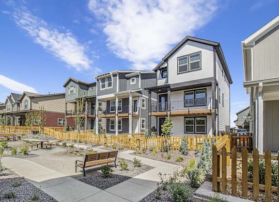 a group of townhomes with benches in a courtyard