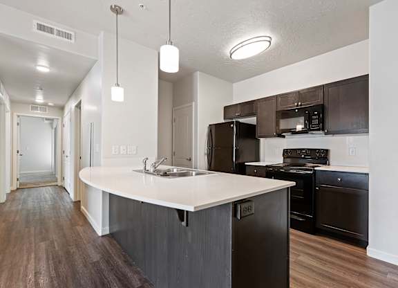 an empty kitchen with an island and black appliances