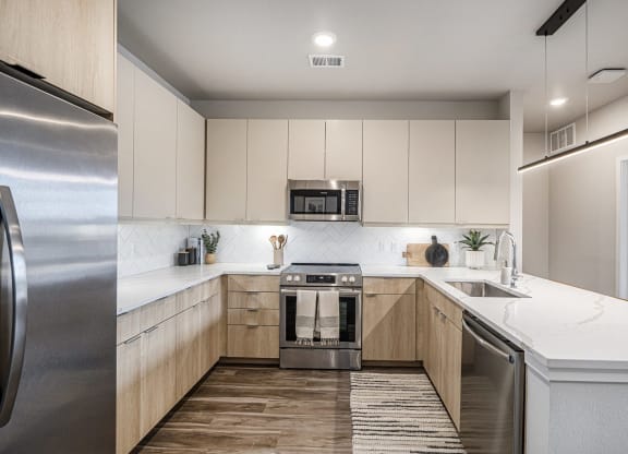 a modern kitchen with white cabinets and stainless steel appliances