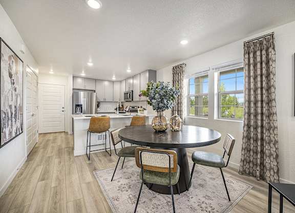 a kitchen and dining room with a table and chairs