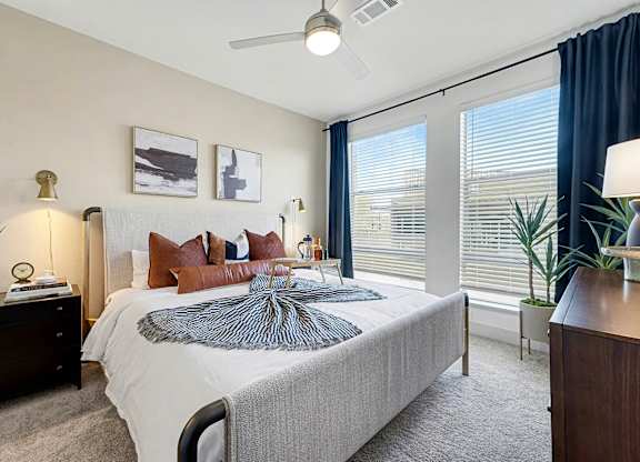 A bedroom with a large bed and a ceiling fan.