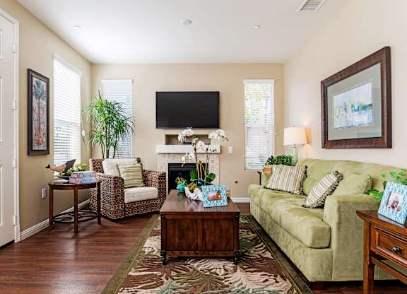 A living room with a couch, chair, and a television.