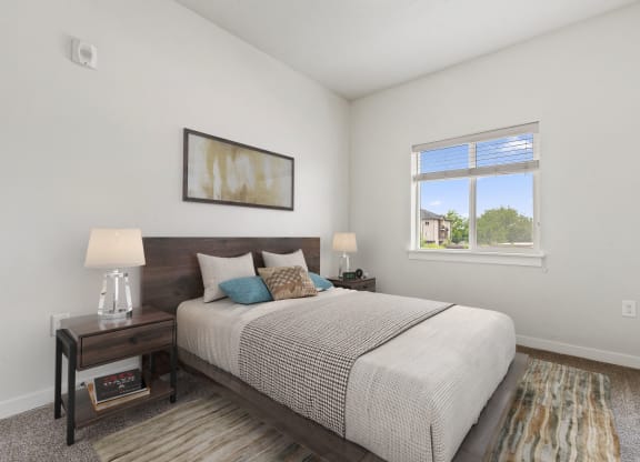 a bedroom with a large bed and two night stands with lamps