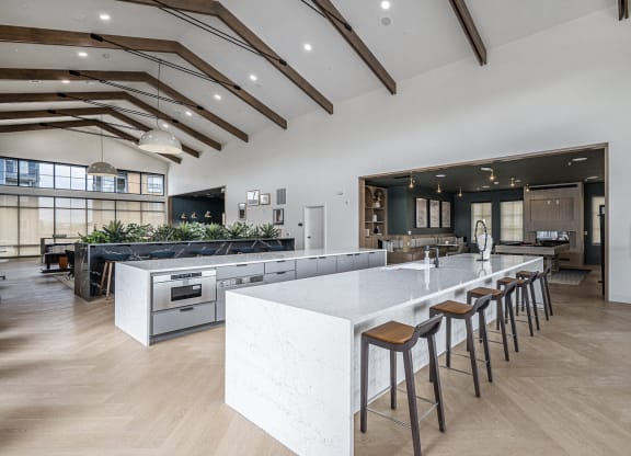 a large kitchen with a large white island and bar stools