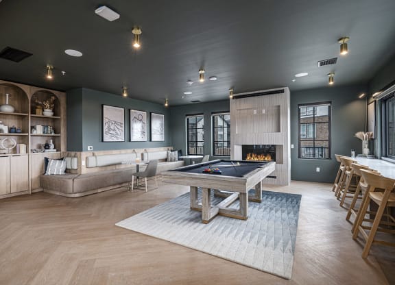 a large living room with a pool table and a kitchen