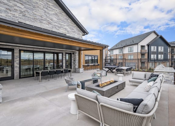 the outdoor patio of a home with furniture and a fire pit