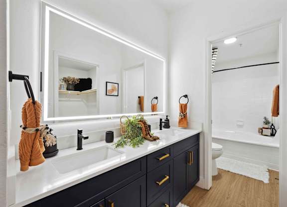 A bathroom with a white sink and a mirror above it.