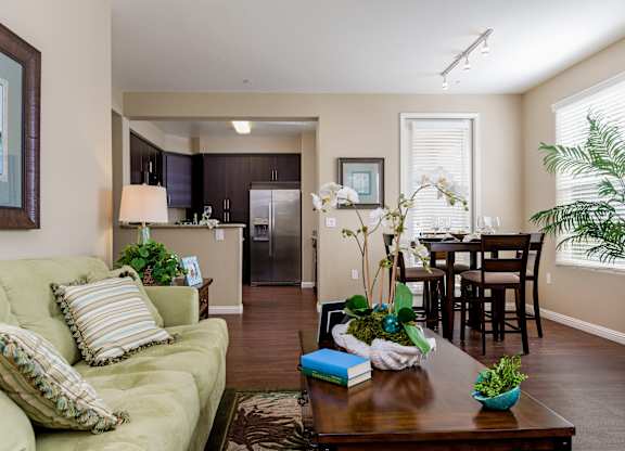 A living room with a green couch and a wooden coffee table.