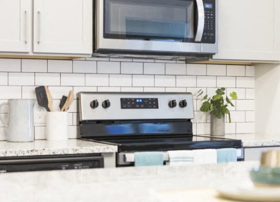 a white kitchen with a stove and a microwave